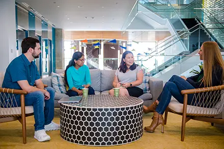 four people talking in a casual office setting
