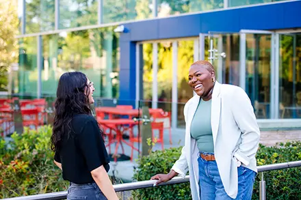 two women speaking outside