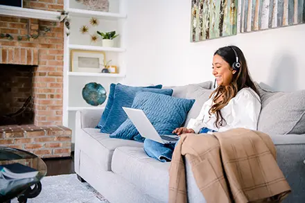 woman on couch and working from laptop