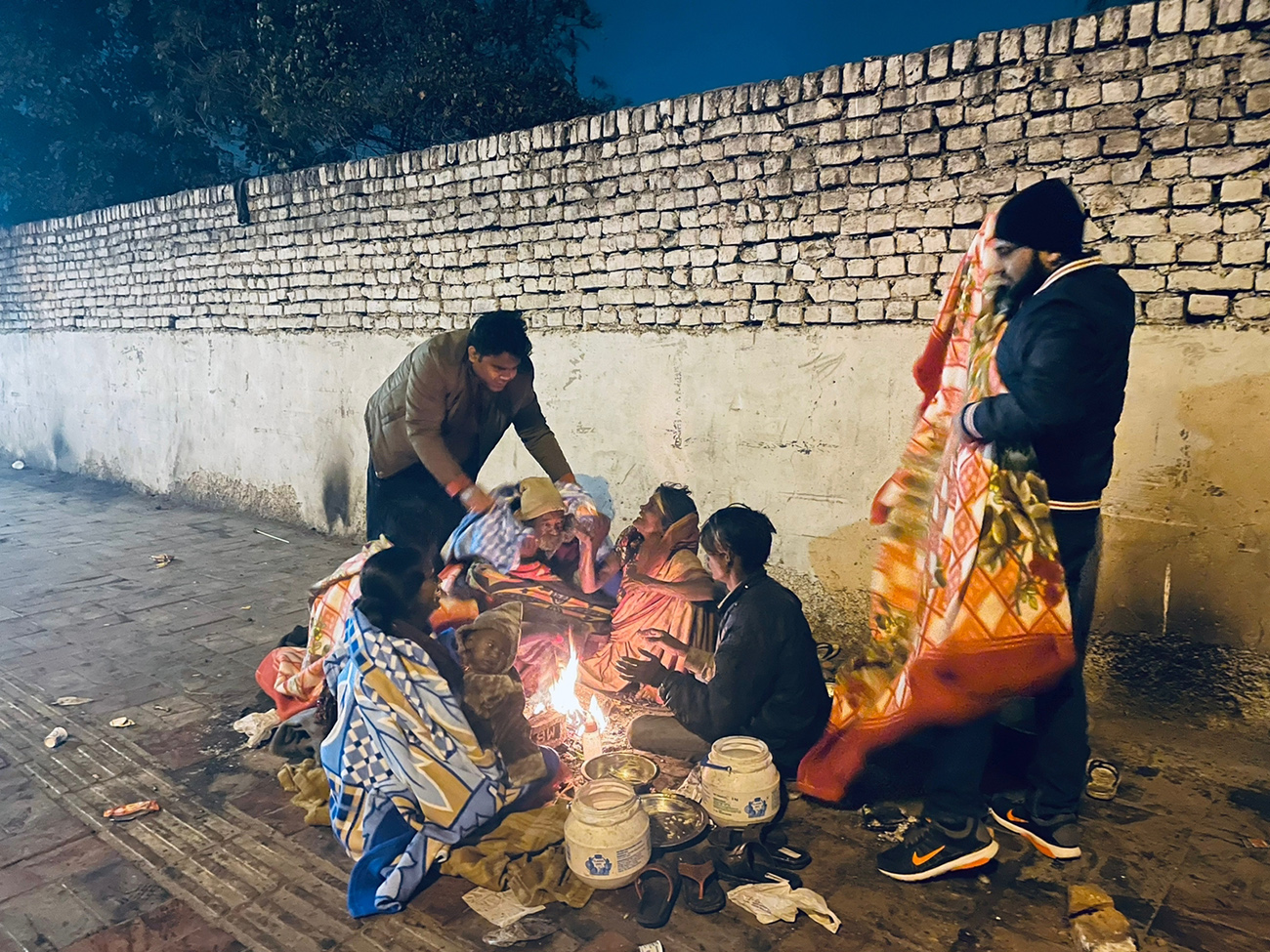 Arm team providing bedsheets to people who sat around the fire