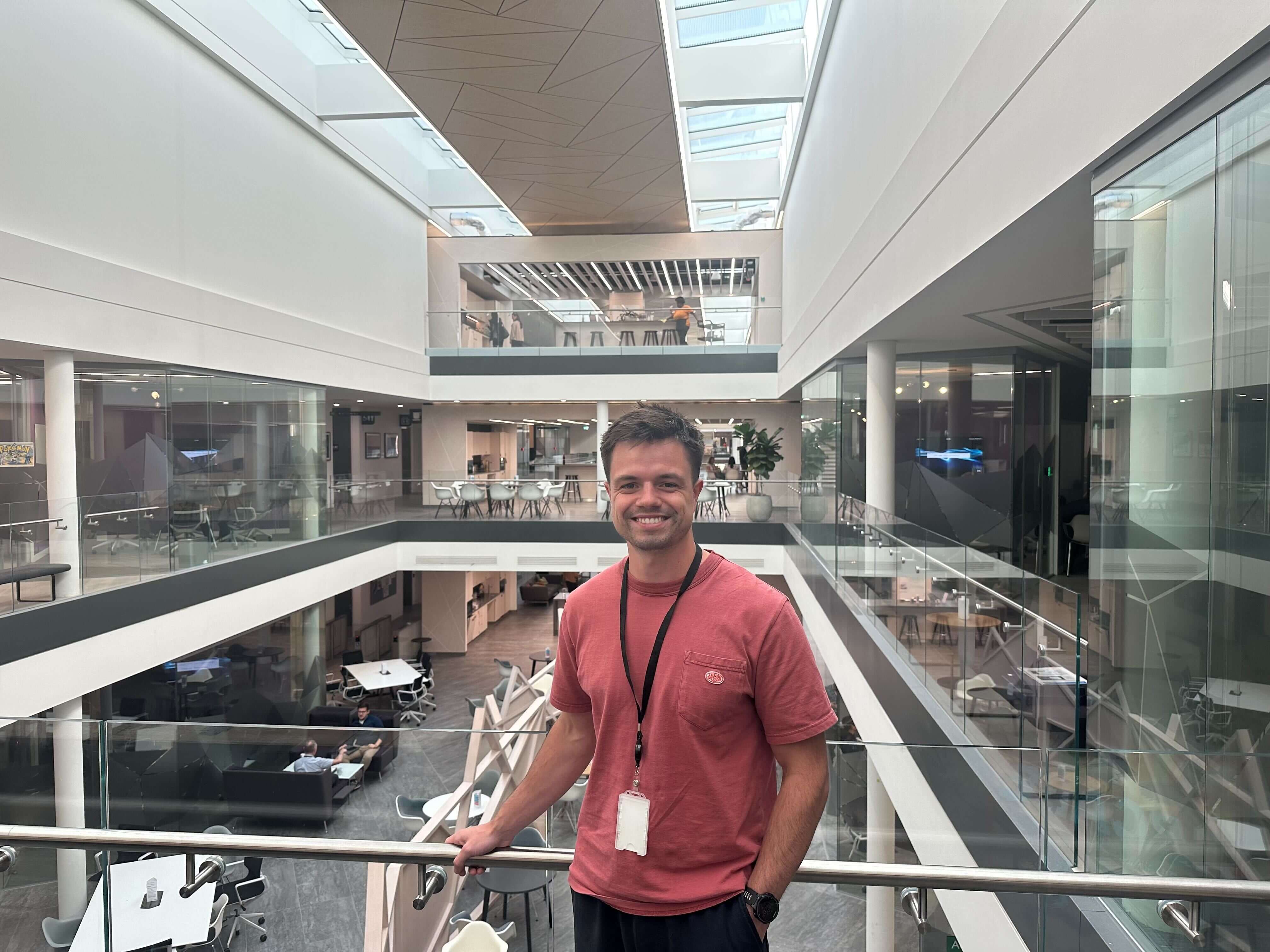 Smiling man in red shirt inside modern building