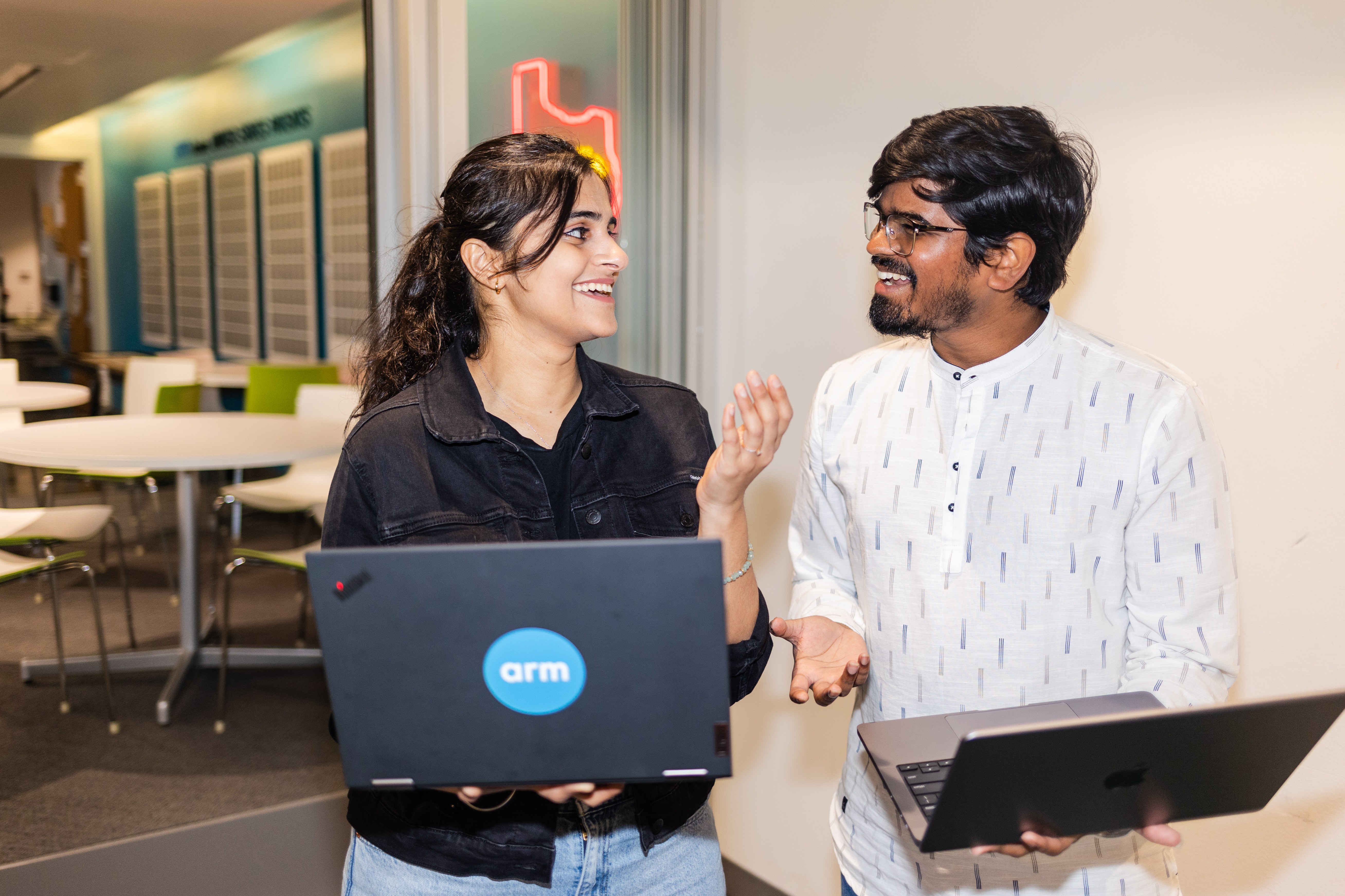 Two people collaborating with laptops.