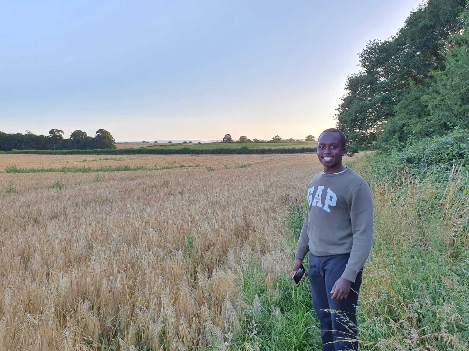 Smiling man standing in a wheat field.