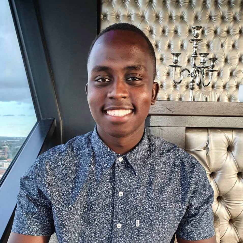 Smiling man in a patterned shirt indoors.