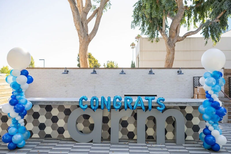 Outdoor celebration setup with "Congrats Arm" sign.