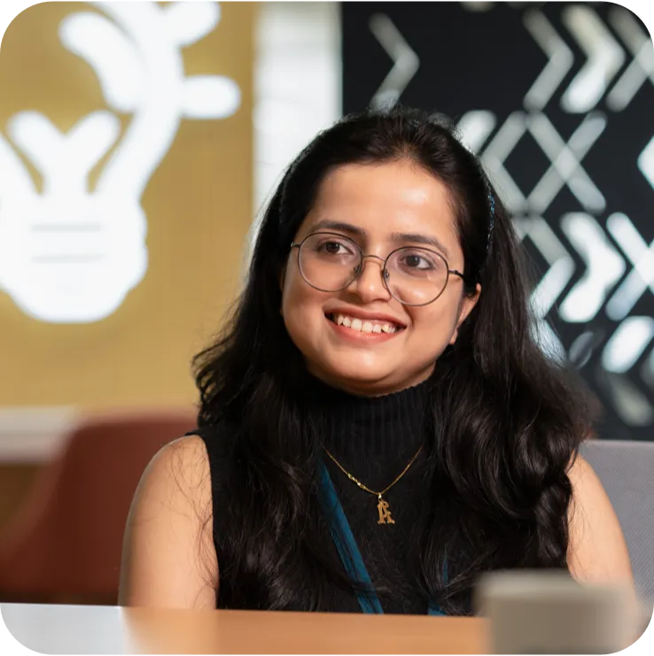 Smiling woman with glasses in an office.